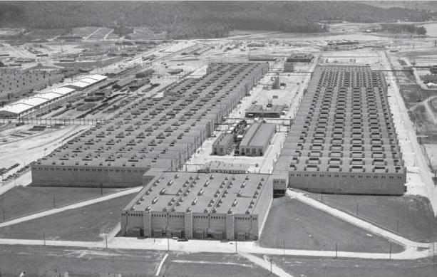 Fotografia zakładu K-25 w Oak Ridge. Czytelnik może zobaczyć skalę przemysłową dyfuzji gazowej. Źródło: Wikimedia Commons, File:K-25_(7609929206).jpg.jpg).