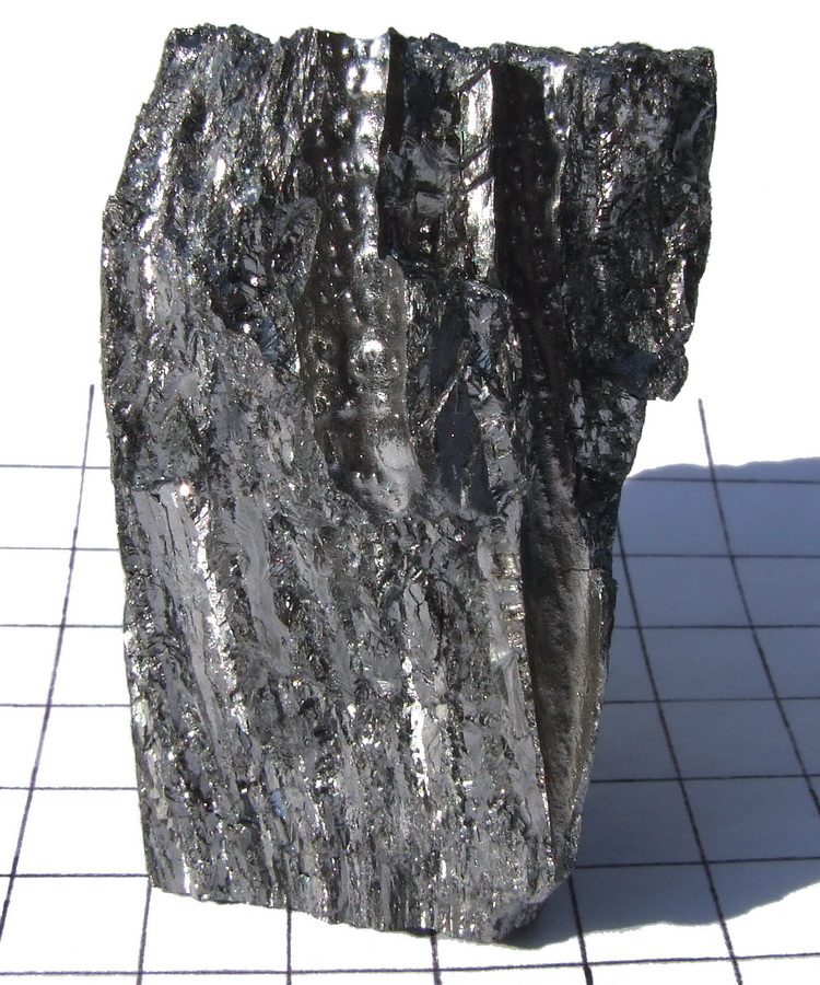 Zdjęcie próbki berylu. Prosty obraz materiałowy przed przejściem do reakcji `(alpha,n)` i roli reflektora. Źródło: Wikimedia Commons, File:Be-140g.jpg.