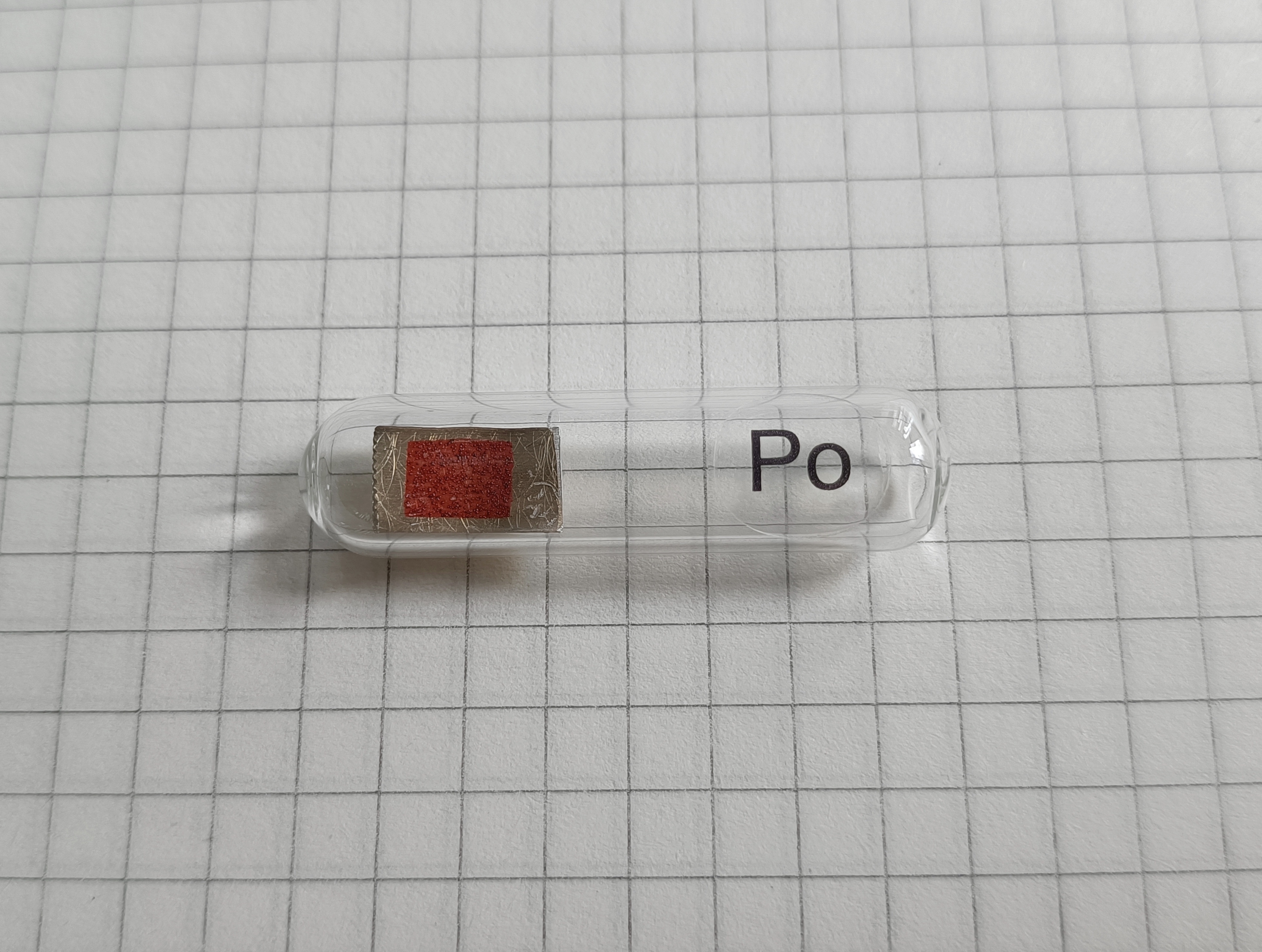 Fotografia polonu osadzonego na blasze mosiężnej. Źródło: Wikimedia Commons, File:Polonium_on_brass_sheet.jpg.