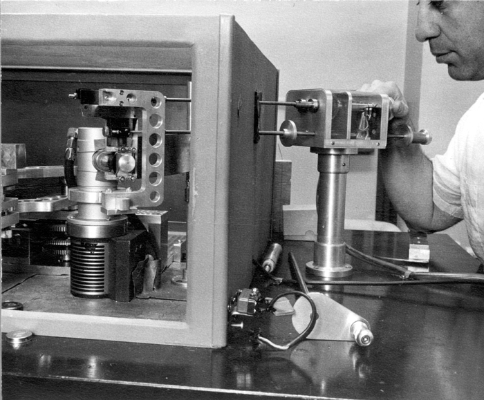 Manualny goniometr XRF jako przykład aparatury fluorescencji rentgenowskiej. Obraz pokazuje zasadę wybicia elektronu i emisji linii X. Źródło: Wikipedia/Wikimedia, File:XRFgoniometer manual.jpg, licencja: Public domain.