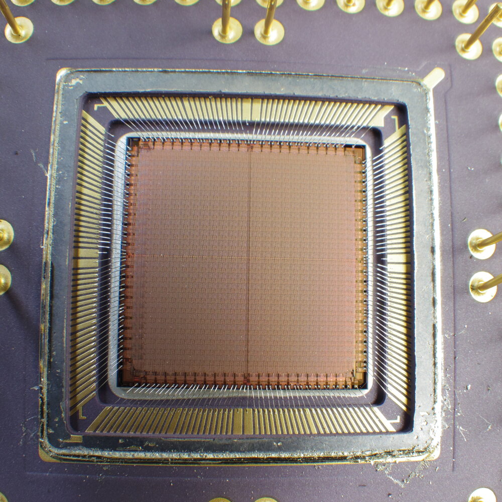 Struktura krzemowa układu FPGA (Xilinx). Setki tysięcy konfigurowalnych komórek logicznych (LUT + przerzutniki) pracują równolegle, połączone konfigurowalną siecią; to fizyczna logika, a nie program wykonywany krok po kroku. Zdjęcie: Wikimedia Commons, *FPGA chip die (Xilinx XC4010-6)*_(22054207552).jpg)