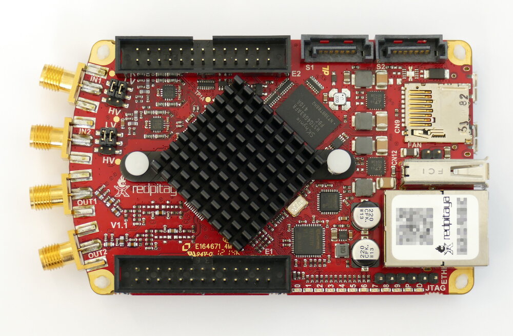 `Red Pitaya STEMlab 125-14` — `Zynq 7010` (FPGA + ARM) z szybkimi przetwornikami `125 MS/s`/`14-bit`. Wygodna platforma eksperymentalna łącząca programowalną logikę z gotowym torem analogowym. Zdjęcie: Wikimedia Commons, *RedPitaya STEMLab FPGA v1.1 topview*