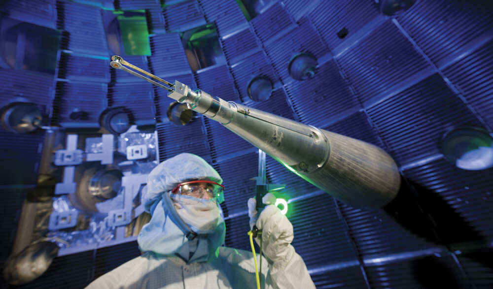 Wnętrze komory tarczowej National Ignition Facility. ICF bada implozję radiacyjną w warunkach laboratoryjnych — ta sama fizyka ablacji, kompresji i niestabilności, która rządzi „secondary" w broni termojądrowej. Zdjęcie: Wikimedia Commons