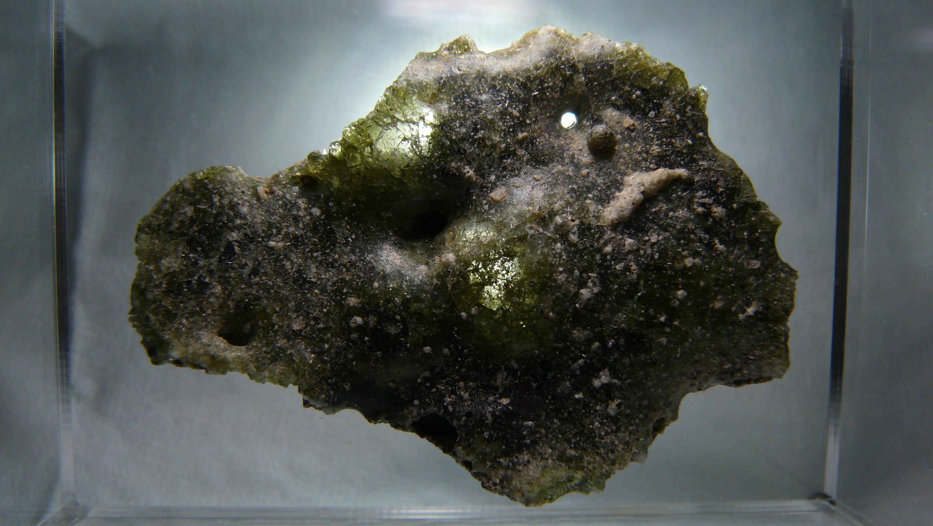 Zdjęcie trynitytu. Bez zdjęcia szkliwa artykuł traci punkt zaczepienia. Źródło: Wikipedia/Wikimedia, File:Trinitite backlight.jpg, licencja: CC BY-SA 4.0.